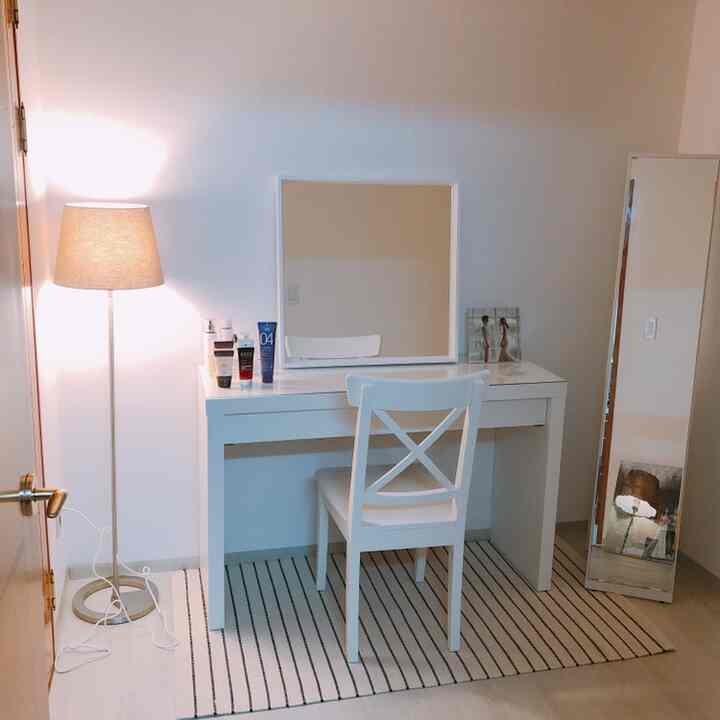 Simple white and natural toned small room featuring a vanity with NORRARYD chair and floor lamp