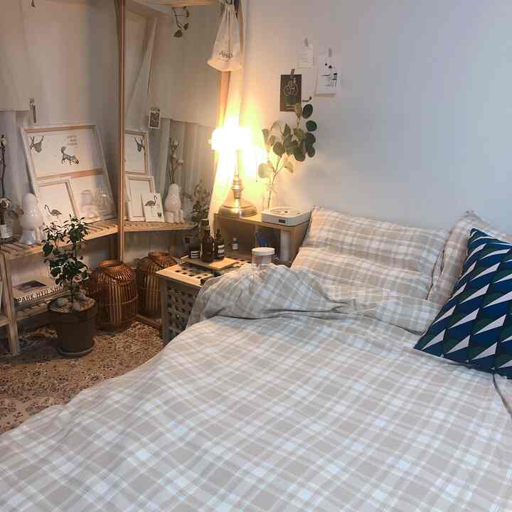 Soft beige and natural wood tones define this studio bedroom featuring warm lighting and cozy decorative items for a comfortable atmosphere