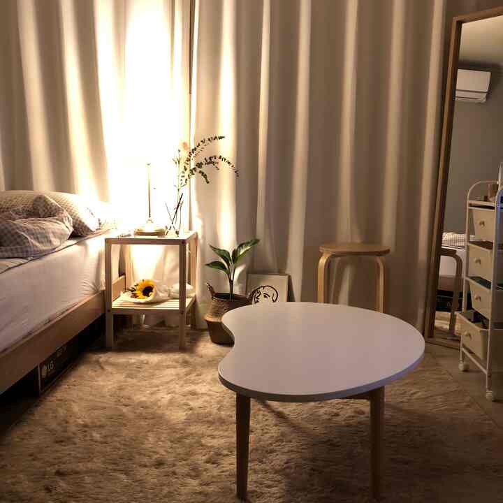 A warm and natural 3-pyeong studio apartment in white and beige tones featuring wood furniture and a rug