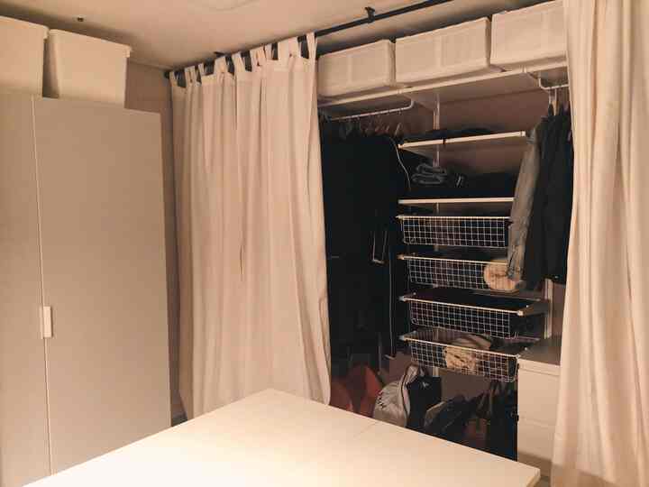 暖かみのあるナチュラルカラーと白を基調としたウォークインクローゼット、カーテンとチェストが整然とした収納空間を演出