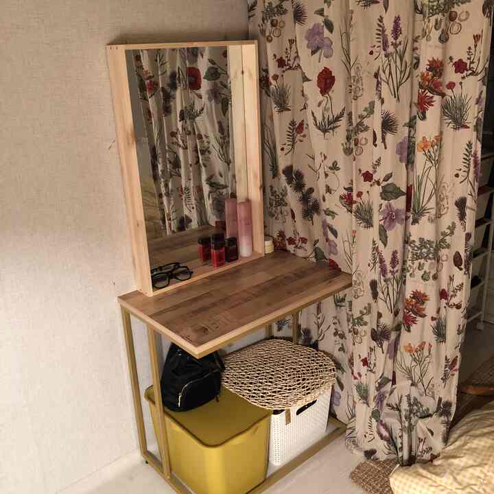 Small studio vanity space featuring natural wood and floral linen curtains