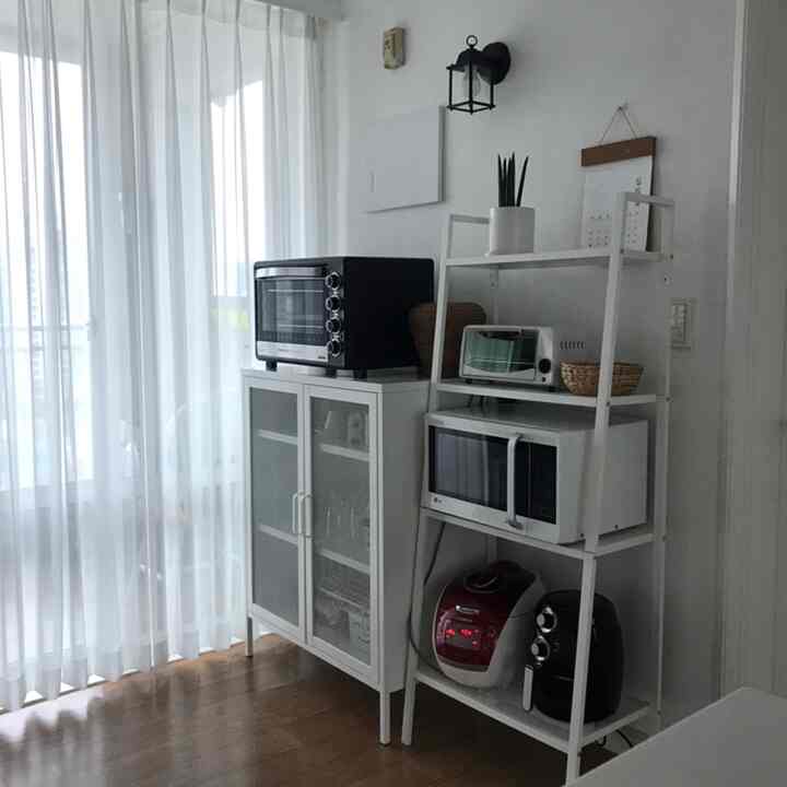 Kitchen space in white and brown tones, featuring white metal rack and cabinet for storage with a clean modern interior style