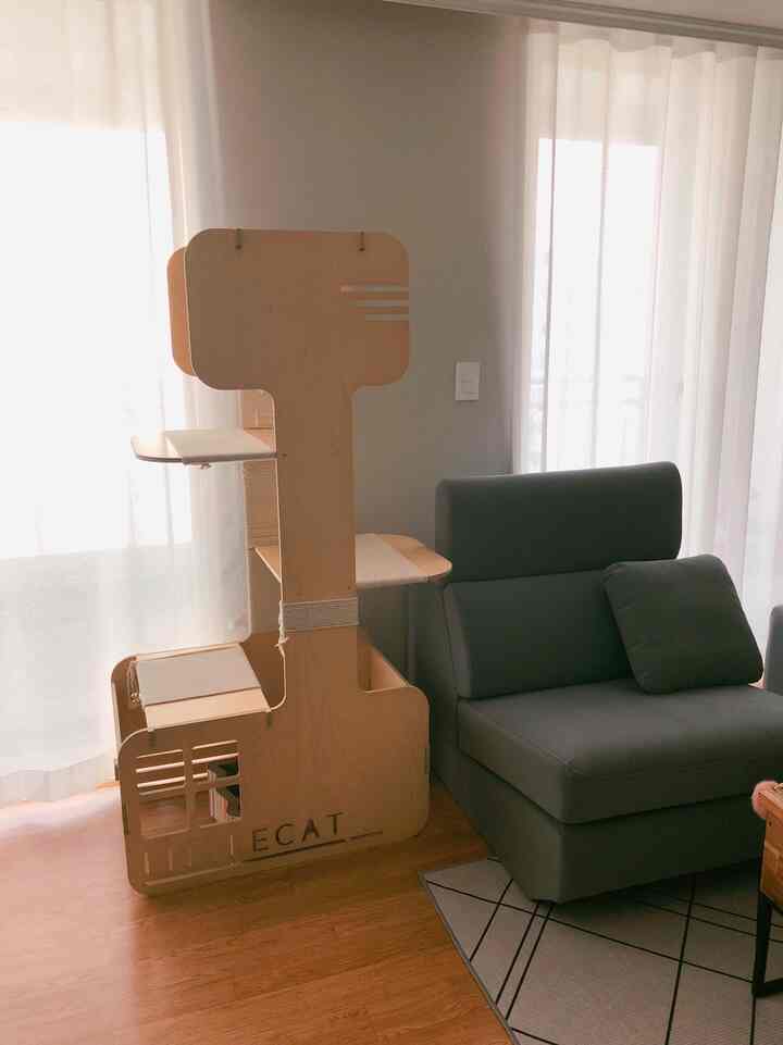 ナチュラルな木目調とグレーのソファがある明るいリビング、大きな窓から自然光が差し込むシンプルモダンな空間