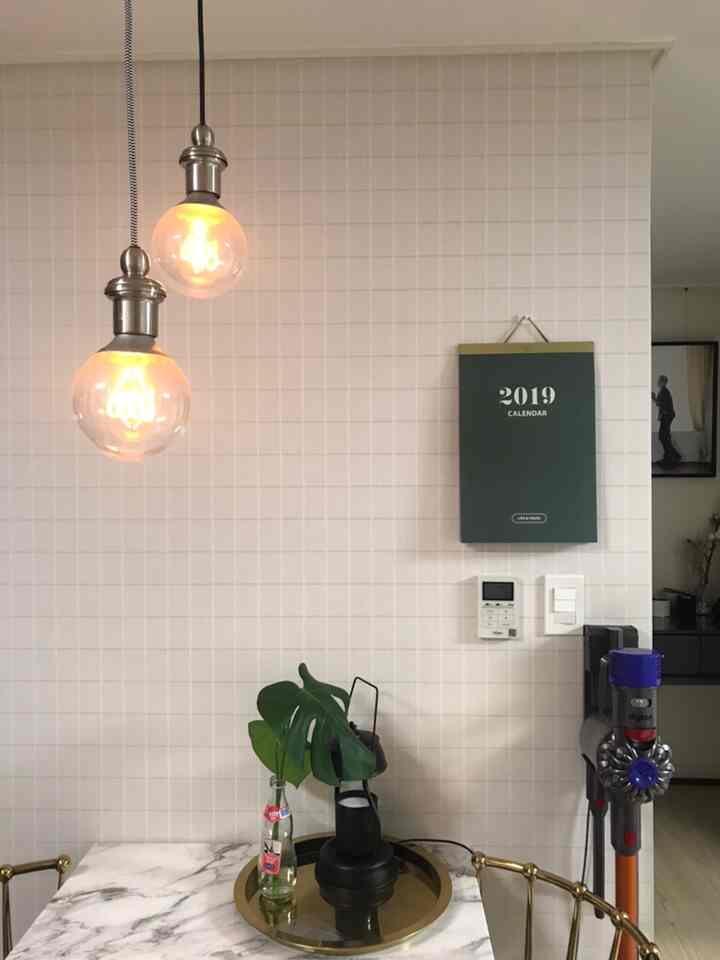White-toned kitchen featuring a gold tray and pendant lights with a clean, natural atmosphere