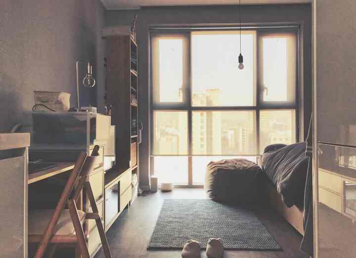 自然光が差し込む木製家具と多機能を備えたコンパクトな一人暮らしの空間