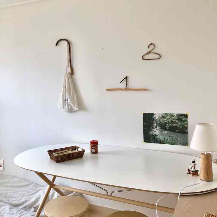 ホワイトと木目調が調和したシンプルなダイニング、木製スツールと白いダイニングテーブルが配置された落ち着いた空間