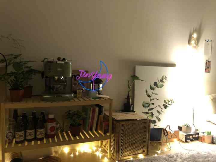 温かみのある木目調と照明が調和した居心地の良いワンルーム、コーヒーマシンと植物が配置されたおうちカフェ風インテリア