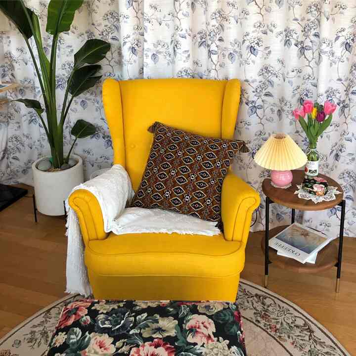 Bright yellow armchair and floor lamp with floral decorations in a vintage living room setting