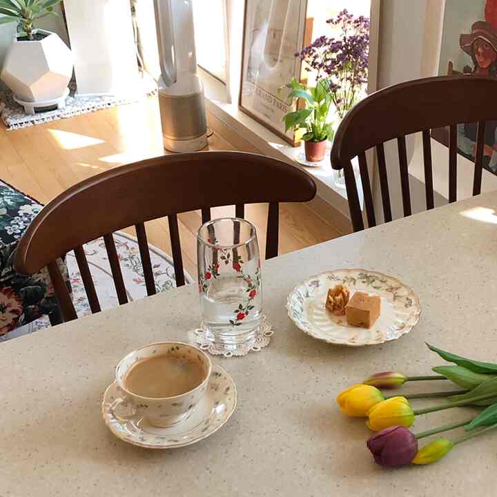 Warm natural-tone kitchen featuring vintage teacups and dishes on a cozy home cafe table
