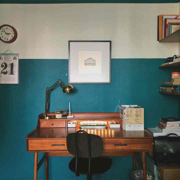 A study space with blue background wall and wooden desk in industrial style, blending retro vibes in a high school student's room