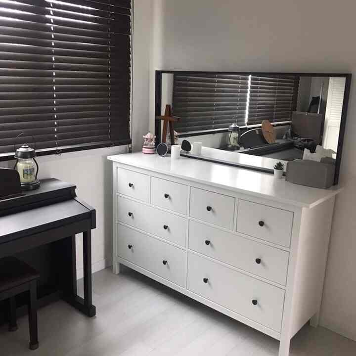 白と茶色の色調のウォークインクローゼット、大きなドレッサーと鏡が配置された印象的な空間