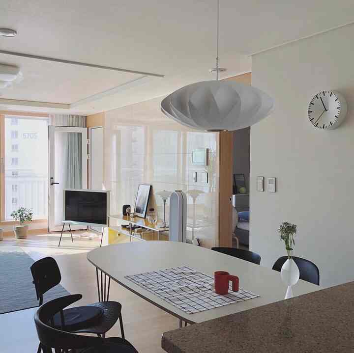 A modern and simple living and kitchen area featuring white and wood tones harmoniously combined