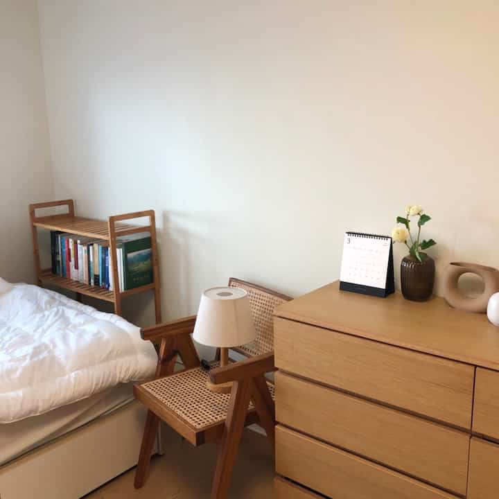 Cozy bedroom with wood tone furniture and white walls and bedding creating a harmonious atmosphere