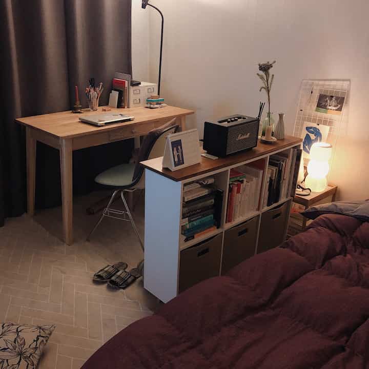 Natural brown and white toned bedroom featuring a desk and bookshelf creating a cozy home office space