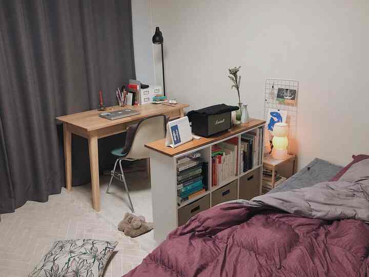 Brown and gray toned bedroom featuring a wooden desk and bookshelf creating a cozy home office space