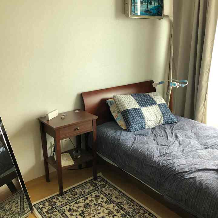 White and brown tone bedroom featuring a bed and nightstand in a cozy personal space