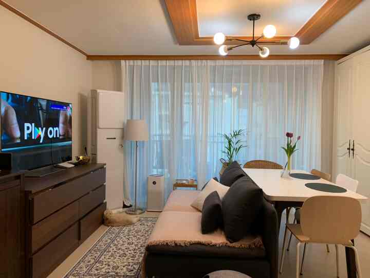 ホワイトとベージュの色調のリビング兼ダイニング、ソファとダイニングテーブルが調和した温かみのあるインテリア