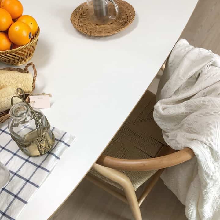 White dining table and natural rattan chair in a cozy kitchen home cafe setting