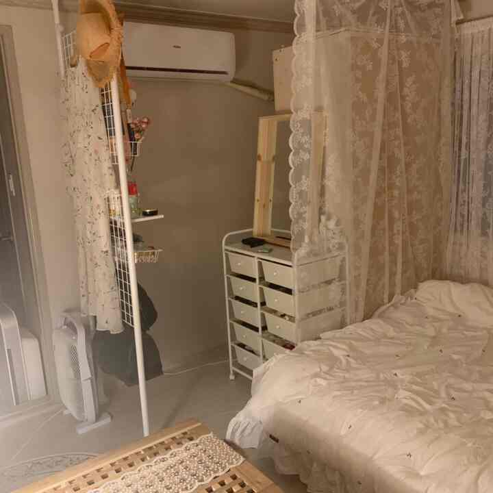 White-toned walk-in closet and bedroom featuring lace curtains and wooden mirror, creating a cozy atmosphere