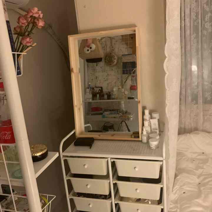 ホワイトと木目調が調和した狭いウォークインクローゼット、化粧台と収納が配置された落ち着いた雰囲気