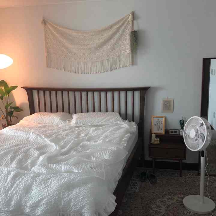 White and brown toned bedroom featuring wooden bed and textured bedding with a cozy natural atmosphere