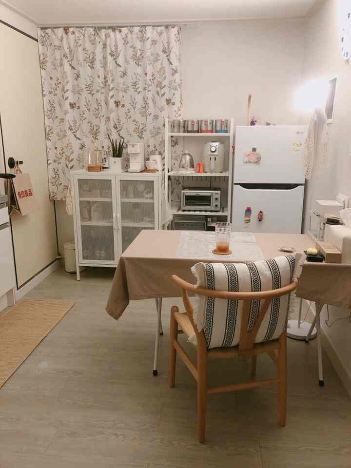 Beige and wood tone kitchen space featuring dining table, wooden chair, and white appliances creating a cozy atmosphere