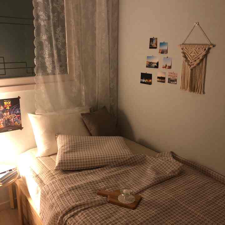 Cozy small bedroom with beige tone and checkered summer bedding and pillows