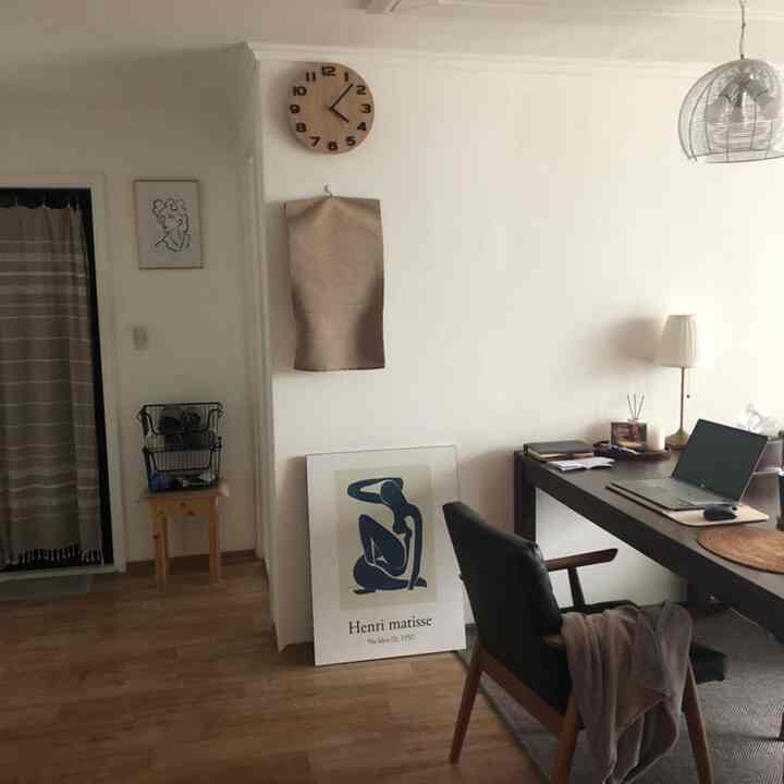 ナチュラルな色調のホームオフィス、木製家具と額縁アートが配置されたシンプルで落ち着いた雰囲気のインテリア