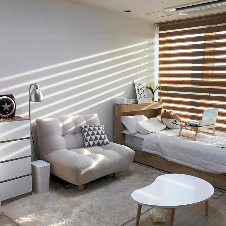 Natural-toned 9-pyeong bedroom featuring sofa, bed, and striped curtains in a cozy modern space