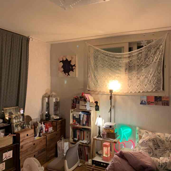 Cozy bedroom in beige and brown tones featuring a bed, nightstand, and neon sign lighting