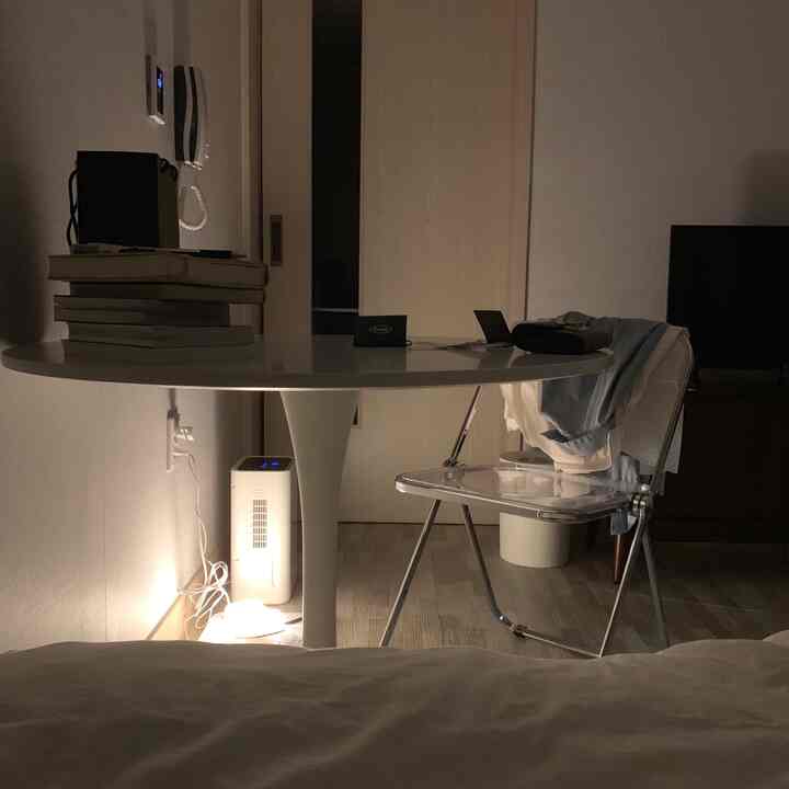 ホワイトと透明素材の円形テーブルとアクリルチェアが配置されたコンパクトなダイニングルーム