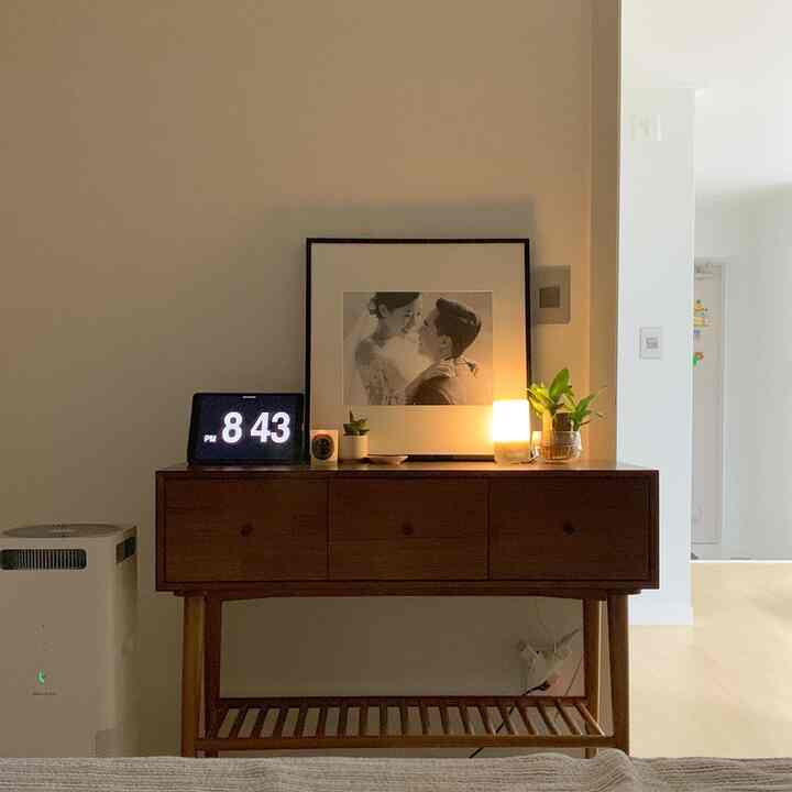 ナチュラルな木目調コンソールと照明が配置された寝室、シンプルで落ち着いた雰囲気のインテリア