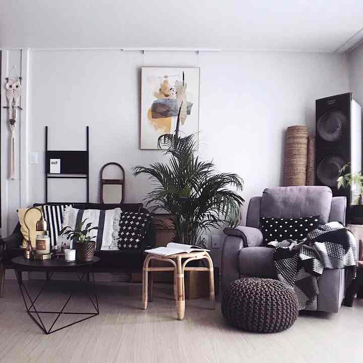 Natural modern living room in gray and black tones featuring a recliner sofa and Areca palm plant, creating a cozy atmosphere