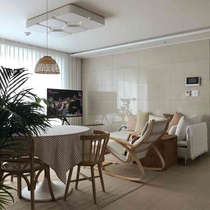 Natural-colored living room featuring a round table, sofa, and rocking chair arranged for living with kids