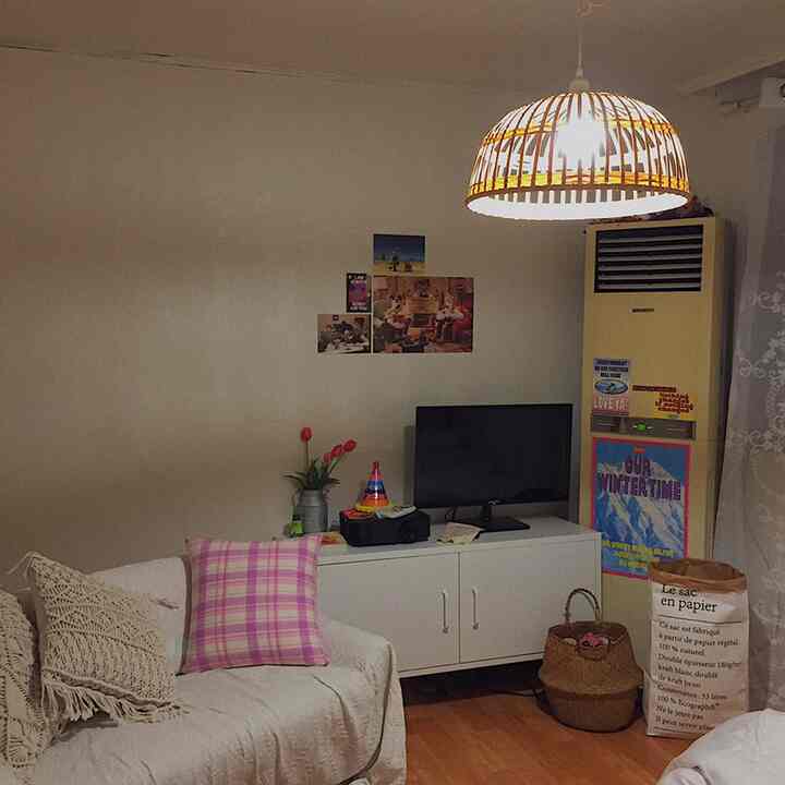 ナチュラルトーンの居心地良いリビング、白いキャビネットとソファが配置されたヴィンテージ風インテリア