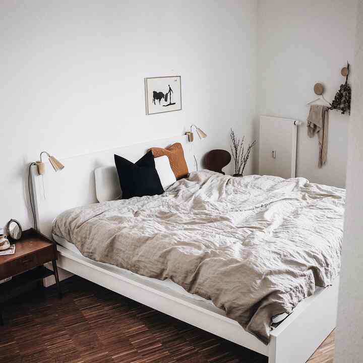 Natural beige and white toned bedroom featuring linen bedding and vintage Ant Chair, creating a cozy atmosphere
