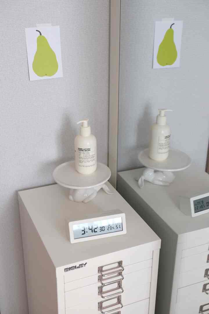 White-toned room featuring a minimal style dresser and digital clock arranged neatly