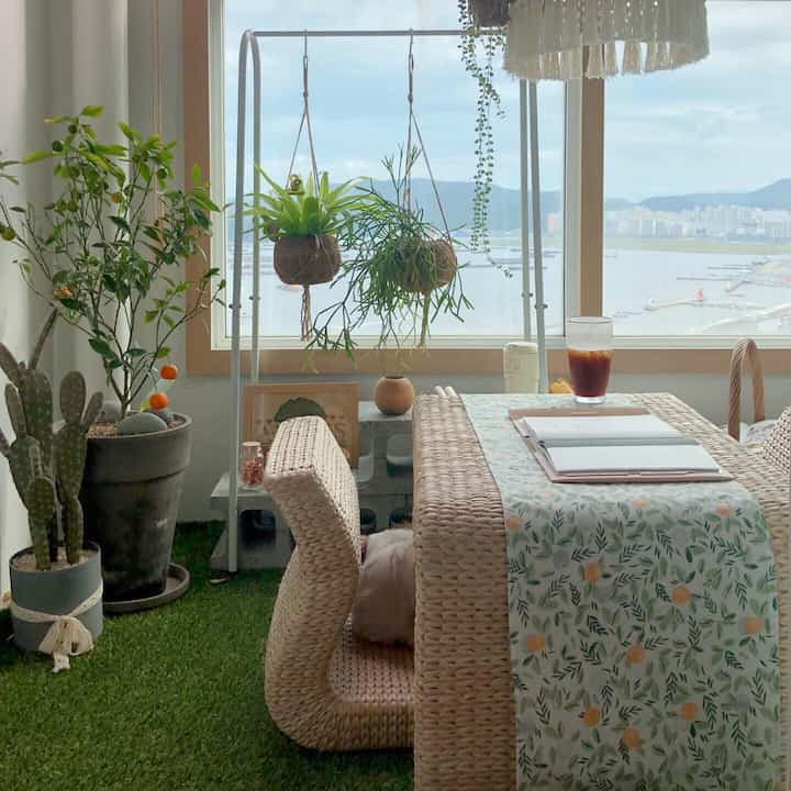 Natural-toned veranda featuring rattan table and plants creating a cozy relaxation space