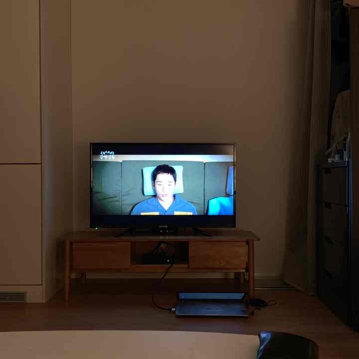 Modern and simple living room with brown wood-tone TV stand and white walls