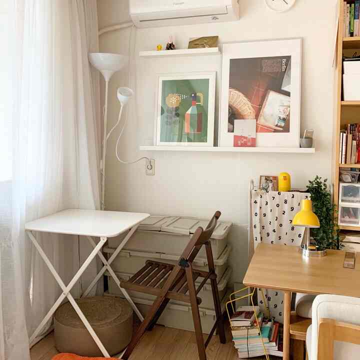 白と茶色のトーンが調和するコンパクトなホームオフィス、デスクと収納ボックス、猫用の爪とぎが配置された雰囲気のあるインテリア