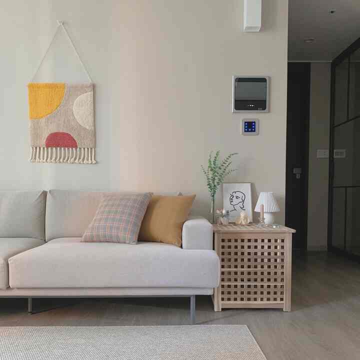 Natural color toned living room featuring beige sofa and wooden side table with calm and clean atmosphere