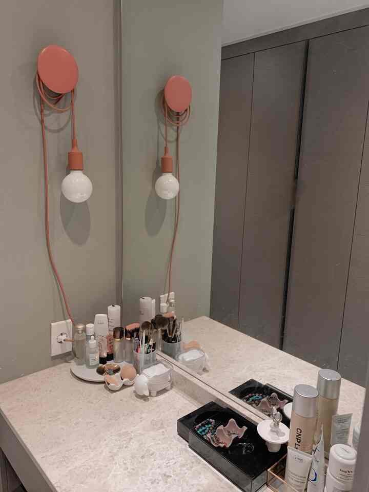 Light brown and terracotta tinted small powder room with marble vanity and large mirror, featuring a natural and calming atmosphere