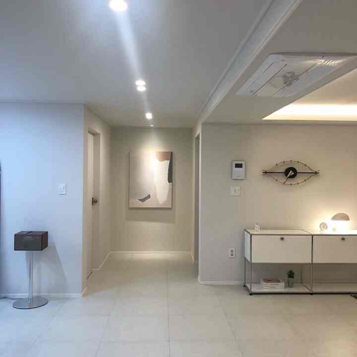 White-toned entrance space featuring minimal furniture and accent lighting with modern interior design
