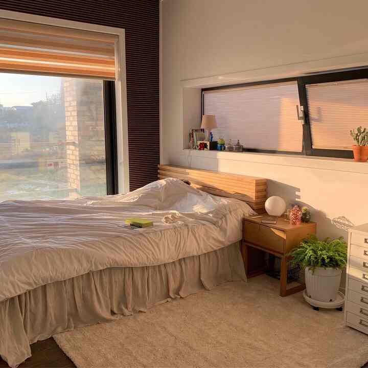 Warm wood and white-toned bedroom featuring cozy bed and rug with inviting atmosphere