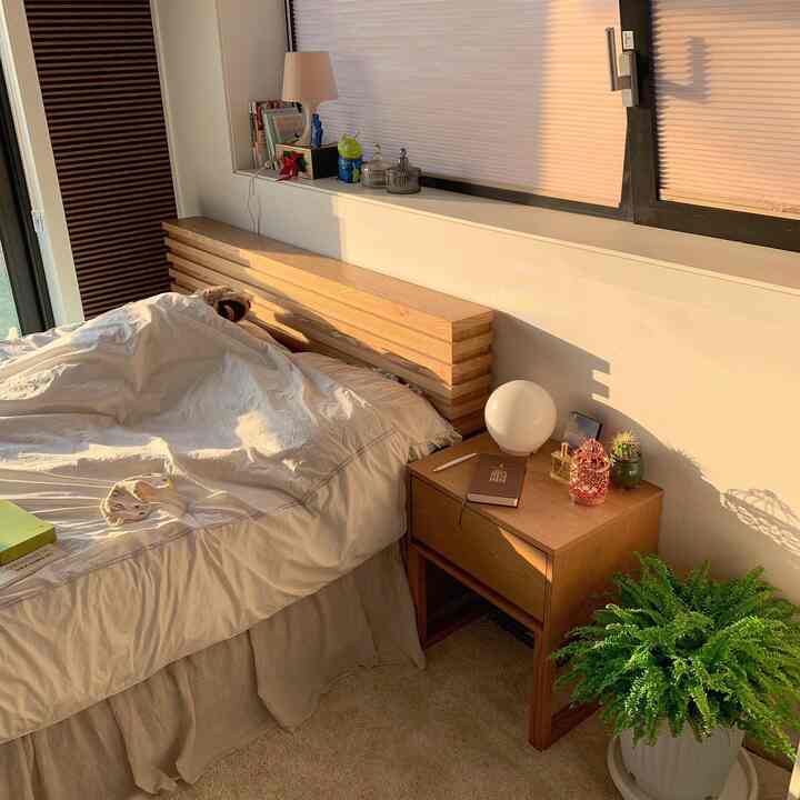 Natural toned bedroom featuring wooden nightstand and headboard, creating a cozy and warm atmosphere
