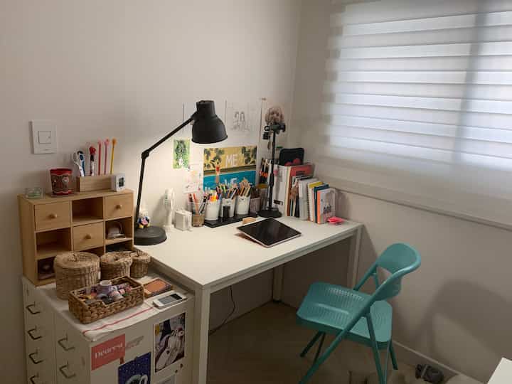 White and wood tone small room home office featuring desk, chair, and wall decor creating a cozy workspace