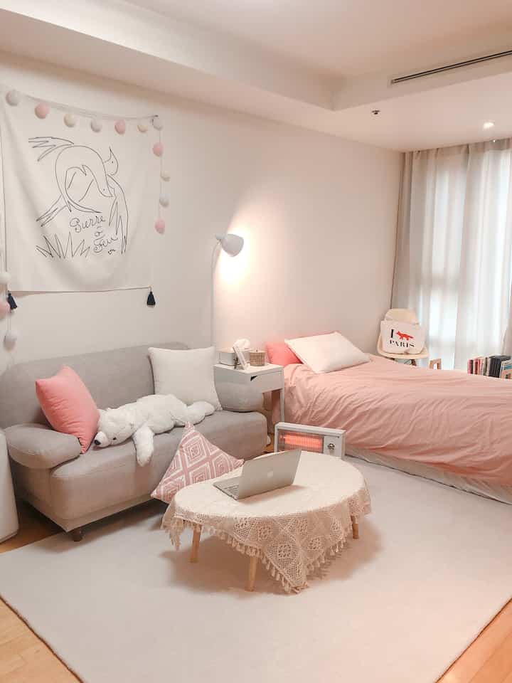 Cozy 10-pyeong studio apartment with white and pink tones, featuring sofa and bed in warm interior design