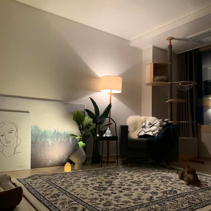 Beige and brown toned living room featuring an armchair and cat tower with a cozy, natural atmosphere