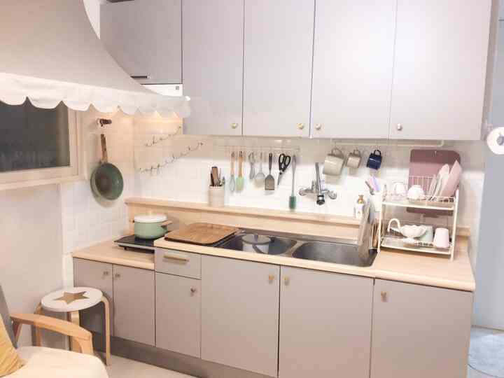 Modern kitchen in white and gray tones featuring stainless sink, kitchen utensils neatly arranged for a clean look