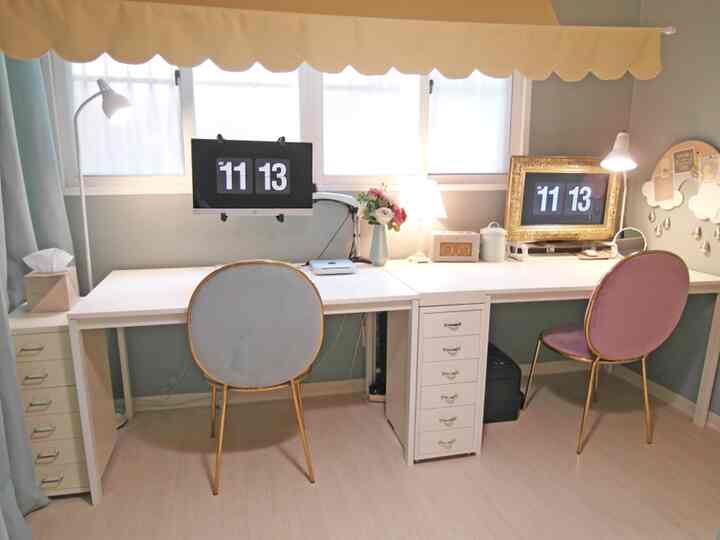 White-toned home office featuring two desks and velvet chairs in a clean, organized workspace
